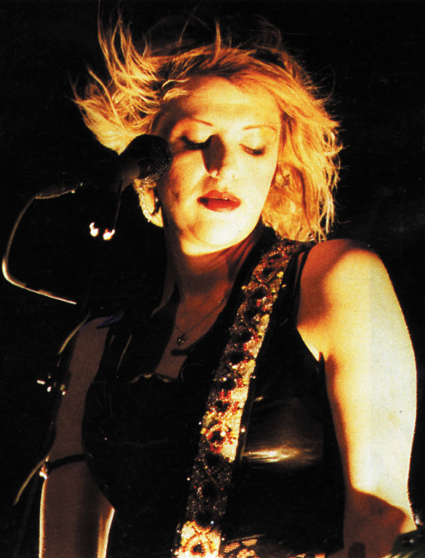 A close up photo of Courtney Love performing